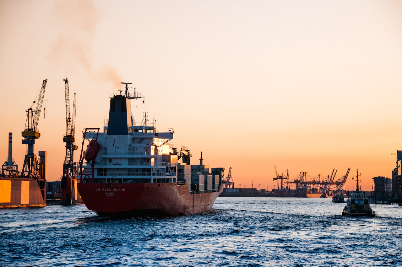Servizi Stunning sunset view of cargo ships and cranes at the Port of Hamburg, epitomizing global trade and logistics.