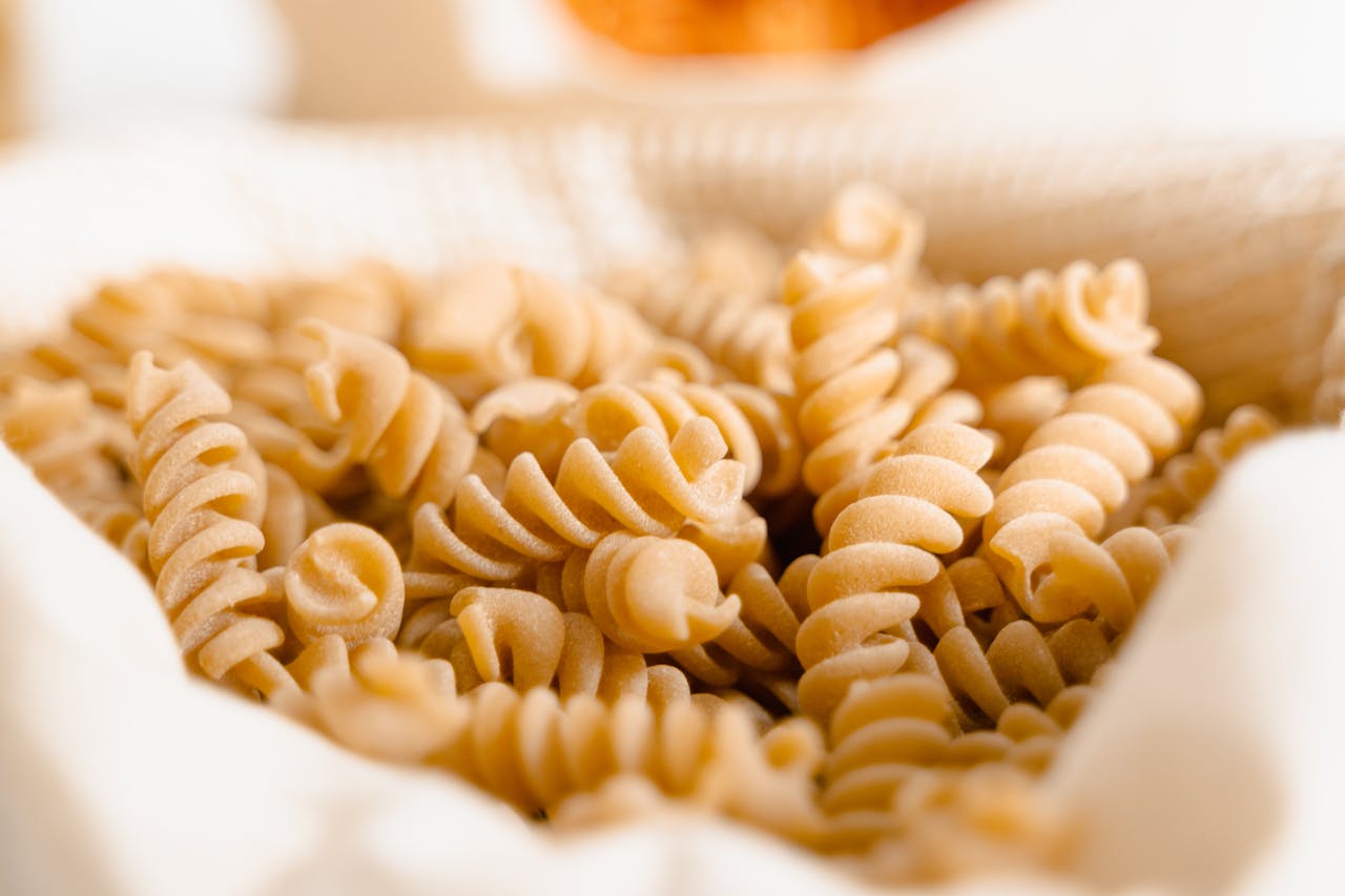 Servizi High-quality close-up of uncooked fusilli pasta in a basket, perfect for food photography.